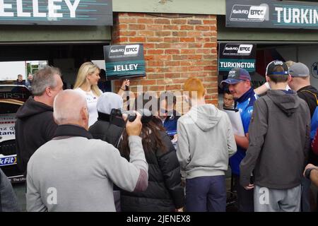 Croft, England, 26 Jun 2022. Stephen Jelley driver for Team BMW signing autographs during the pit lane walkabout at the British Touring Car Championship meeting at Croft Circuit. Credit: Colin Edwards Stock Photo