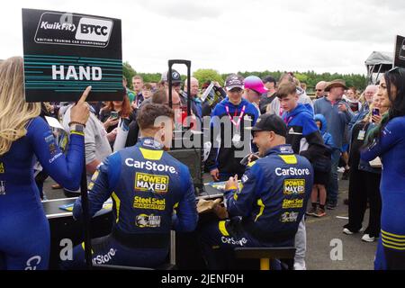 Croft, England, 26 Jun 2022. Ash Hand and Michael Crees signing autographs during the pit walk at the British Touring Car meeting at Croft Circuit. Credit: Colin Edwards Stock Photo