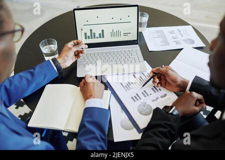 Top view at two successful business people managing finances and pointing at data charts, copy space Stock Photo