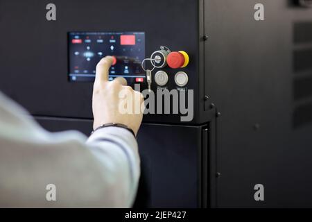 Operator controls modern equipment using a touch control panel. Selective focus. Stock Photo