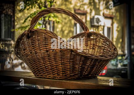 A Big Wicker Basket on a table outdoors Stock Photo