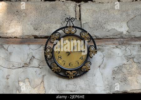 old broken clock ussr hangs on the white wall of a house in the street in the sun, broken old wall clock Stock Photo