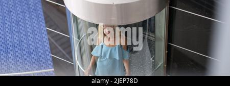 Beautiful woman in the glass elevator of the building Stock Photo