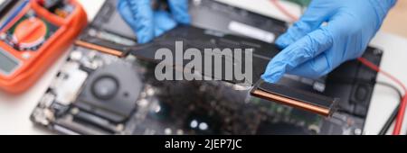 Gloved hands hold a laptop microcircuit, close-up Stock Photo