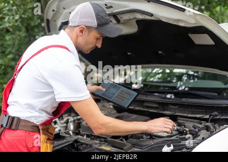 mechanic using digital tablet in workshop Stock Photo