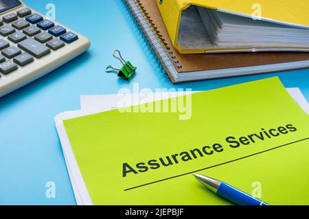 Pile of papers about assurance services and folder. Stock Photo