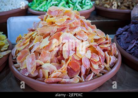 Bowl with dried papaya fruit. Slices displayed at street market stall Stock Photo