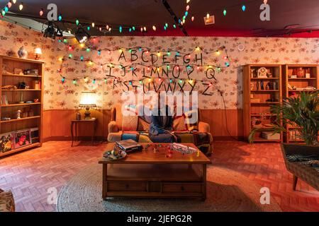Paris, France - June 27, 2022: Tourist girl in Living room in Stranger Things Pop-up store on avenue Champs Elysees Stock Photo