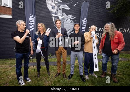 Radio presenter Wim Oosterlinck, Luc De Vos' widow Sandra Heylen, Gent Mayor Mathias De Clercq, Artist Michel Steppe, Son Bruno De Vos and Gorki bass player Erik Van Biesen pictured during the unveiling of the mural in honor of Luc De Vos in Ghent, Tuesday 28 June 2022. To celebrate the 30th anniversary of Gorki's debut album, DJ Wim Oosterlinck of radiostation 'Willy' launched a call to listeners. From that came the suggestion to make a mural. Street artist Steppe immortalizes the folk hero Luc De Vos with a gigantic mural in the center of Ghent. The special tribute will be unveiled today dur Stock Photo