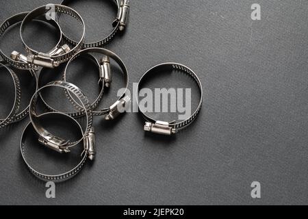 Metal hose clamp on black background. Empty space for text Stock Photo