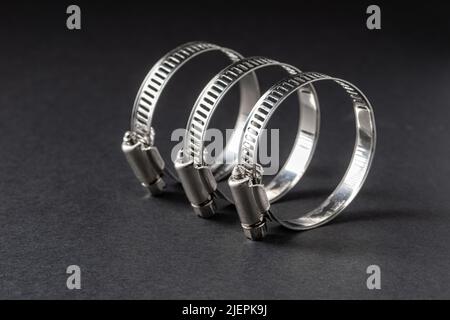 Metal hose clamp on black background. Empty space for text Stock Photo