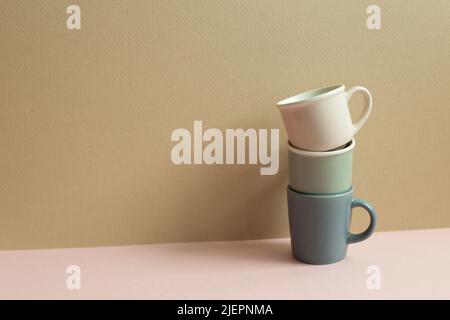 Stack of cups on pink table. beige wall background Stock Photo
