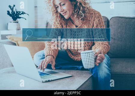 Young woman using laptop sitting on the sofa at home. Alternative workplace with computer, Modern people in smart working activity, Leisure indoor sur Stock Photo