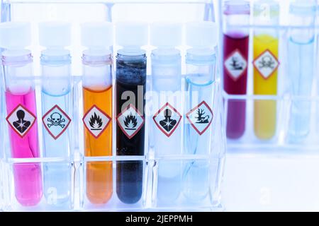 Chemicals in test tubes and symbols used in laboratory or industry Stock Photo