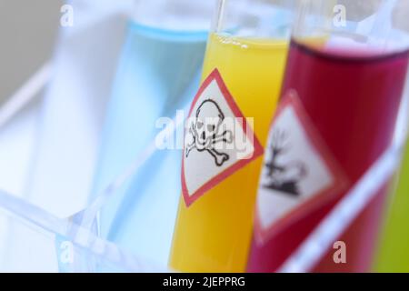 Chemicals in test tubes and symbols used in laboratory or industry Stock Photo