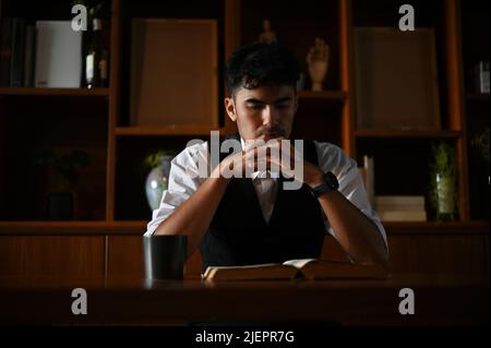 Professional and stressed asian businessman or male executive manager pensive thinking and planning his project alone in the office. Stock Photo