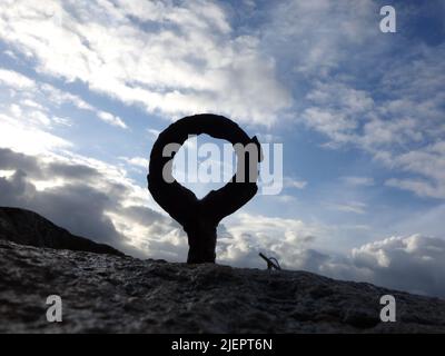 An old rusty mooring ring, with a overcast sky in the background. Stock Photo