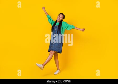 Full body portrait of cheerful overjoyed lady enjoy dancing clubbing isolated on yellow color background Stock Photo