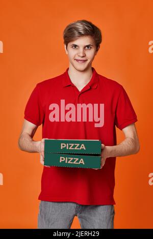 Pizza delivery man in red t-shirt holding cardboard boxes Stock Photo
