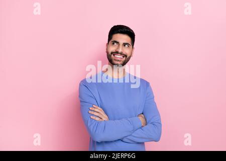 Photo of funny dreamy arabian man wear long sleeve shirt arms folded looking empty space isolated pink color background Stock Photo