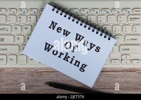 Top view of new ways of working text on notepad on top of keyboard. New working concept Stock Photo