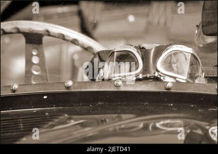 classic racing D Type Jaguar car windscreen, steering wheel and goggles Stock Photo