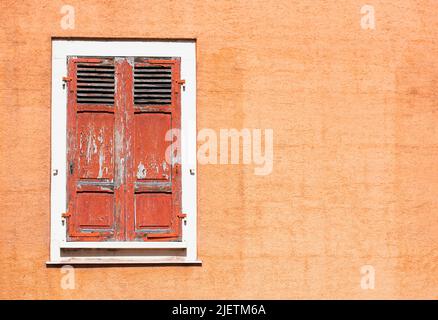 Red wooden vintage shutters and stone wall, traditional European architecture Stock Photo