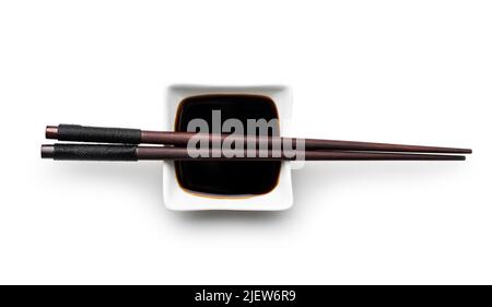 Soy sauce in bowl and chopsticks isolated on a white background. Stock Photo