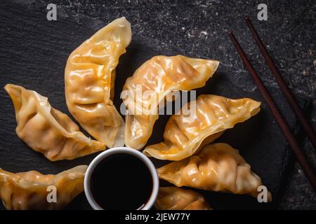 Chinese dumplings abd soy sauce on a cutting board. Top view. Stock Photo