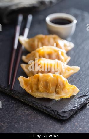 Chinese dumplings abd soy sauce on a cutting board. Stock Photo