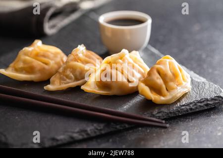 Chinese dumplings abd soy sauce on a cutting board. Stock Photo