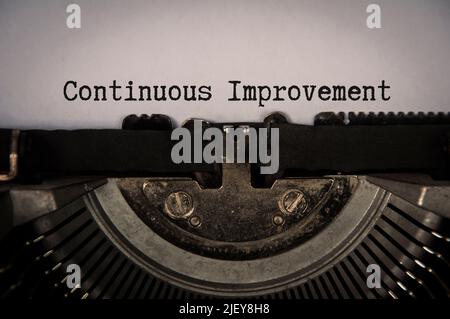 Continuous improvement text on an old typewriter in vintage color. Business concept Stock Photo