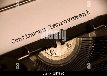 Side view of continuous improvement text on an old typewriter in vintage color. Business concept Stock Photo