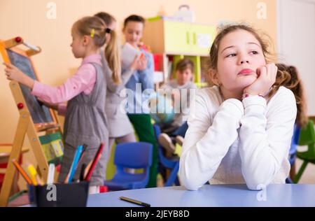 Sad bored schoolgirl in classroom at break Stock Photo