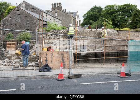 Coping stone layer being added to wall at Kayley Hill, Long Preston 28/6 22 .Also connecting up up to the older.lef-sidet,(non block-backed) section. Stock Photo