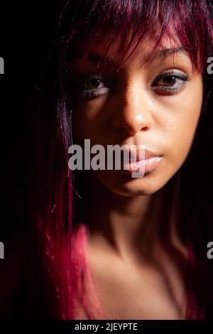 Red hair: strong and independent. A strong and powerful look on the face of an independent young woman. From a series of images with the same model. Stock Photo