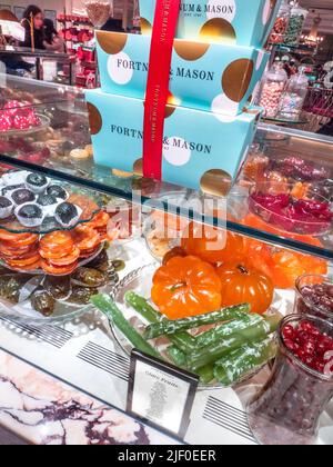 Fortnum & Mason Food Hall with luxury display of hand made glacé fruits selection, Angelica, Kiwi slices , Black figs, Lemon slices, Peach halves, etc Stock Photo