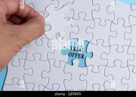 Person's Hand Holding Piece Of Puzzle With Text Trial Offer. Stock Photo