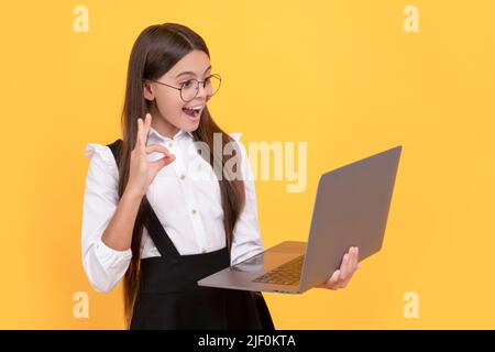 amazed kid in school uniform and glasses wavig hello to laptop screen, communication Stock Photo