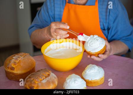 one grandmother smears Easter cake with protein cream Stock Photo