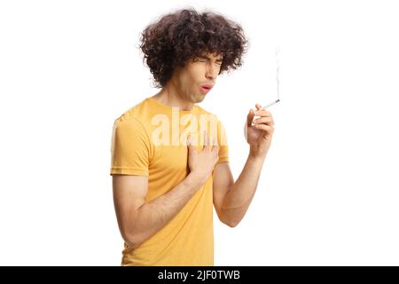 Young man with curly hair smoking a cigarette and coughing isolated on white background Stock Photo