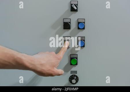 Male engineer worker turns on the buttons on the control panel photo close up of a male hand Stock Photo