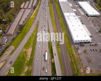 Top view of the highways, the roof of a large industrial building, a warehouse, green lawns, cars. Infrastructure, map, planning, topography, ecology, Stock Photo