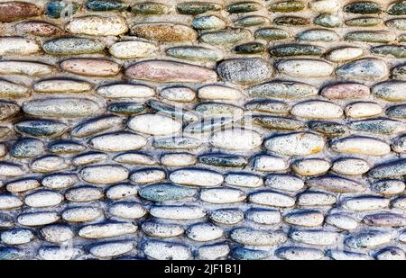 Rough stone wall as creative background texture. Natural stones masonry with uneven seams. Stone wall background Stock Photo