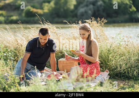 Social media internet addiction, phubbing. Young couple reading social media on their smart phones while having dating Stock Photo