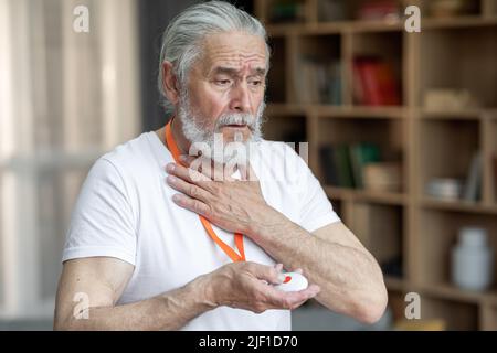 Sick senior man pushing panic button on emergency equipment Stock Photo