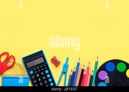 Top view of school supplies with space for text on yellow background. Back to school concept Stock Photo
