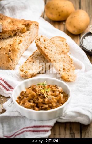 Potato bread with spelt flour and roasted onions on wooden table Stock Photo
