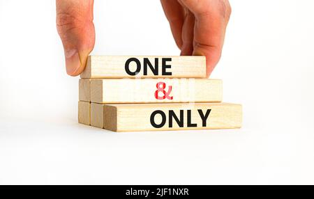 One and only symbol. Concept words One and only on wooden blocks on a beautiful white table white background. Businessman hand. Business, motivational Stock Photo