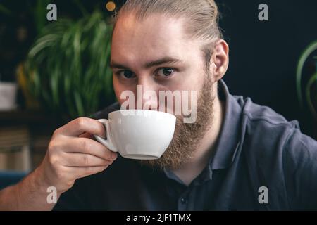 Portrait of a young bearded man with a cup of tea. Stock Photo